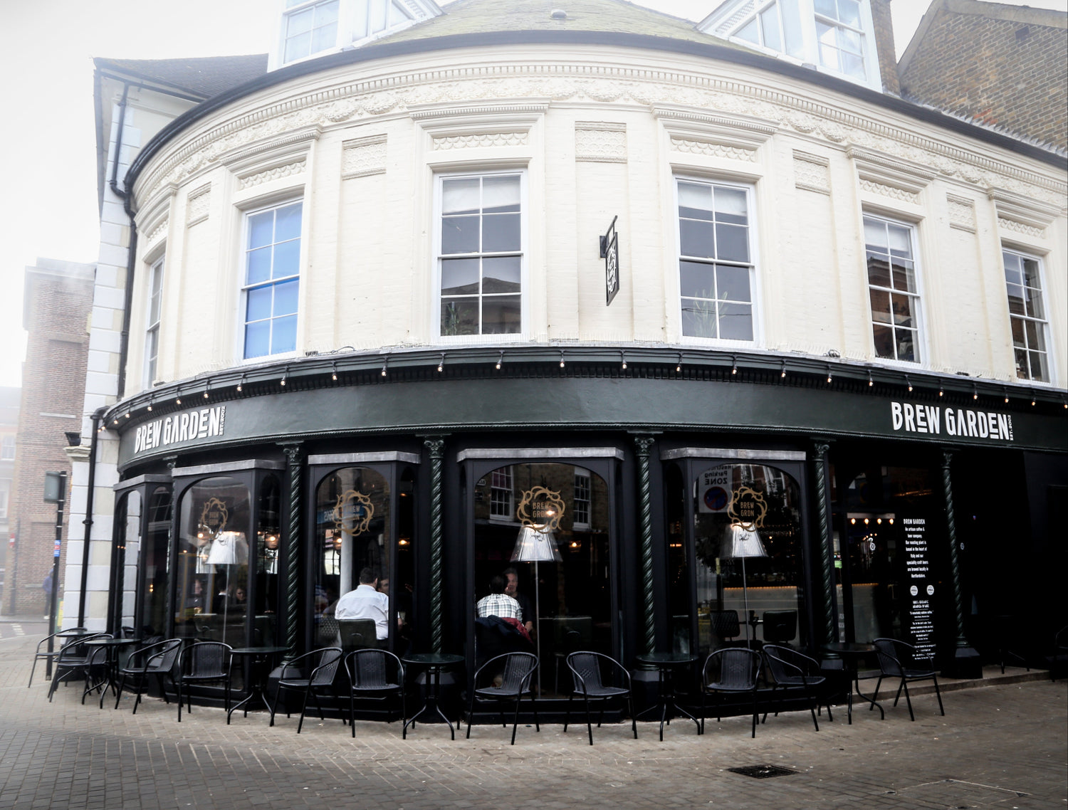 Corner building with 'Brew Garden' sign and outdoor seating area.