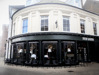 Corner building with 'Brew Garden' sign and outdoor seating area.
