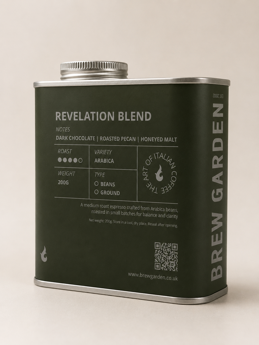 A matte dark green metal coffee canister with silver metal trim and lid, labeled 'REVELATION BLEND' by Brew Garden, photographed on a light beige background.